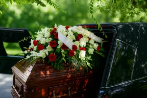 Cercueil recouvert d'une composition florale de roses rouges et blanches